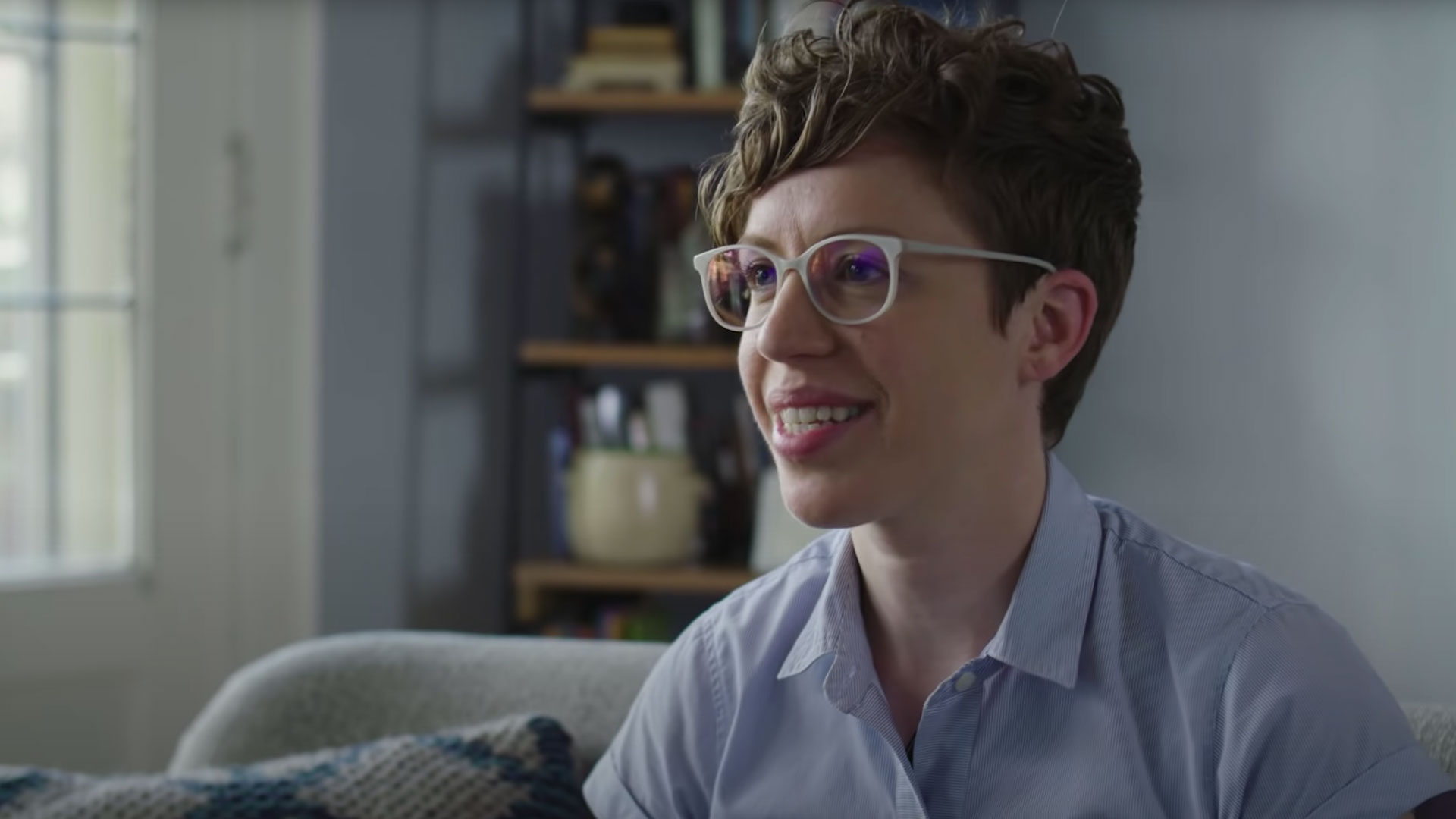 Beth Pahlicek, an internal communications manager, has short, wavy brown hair and white frames for glasses 