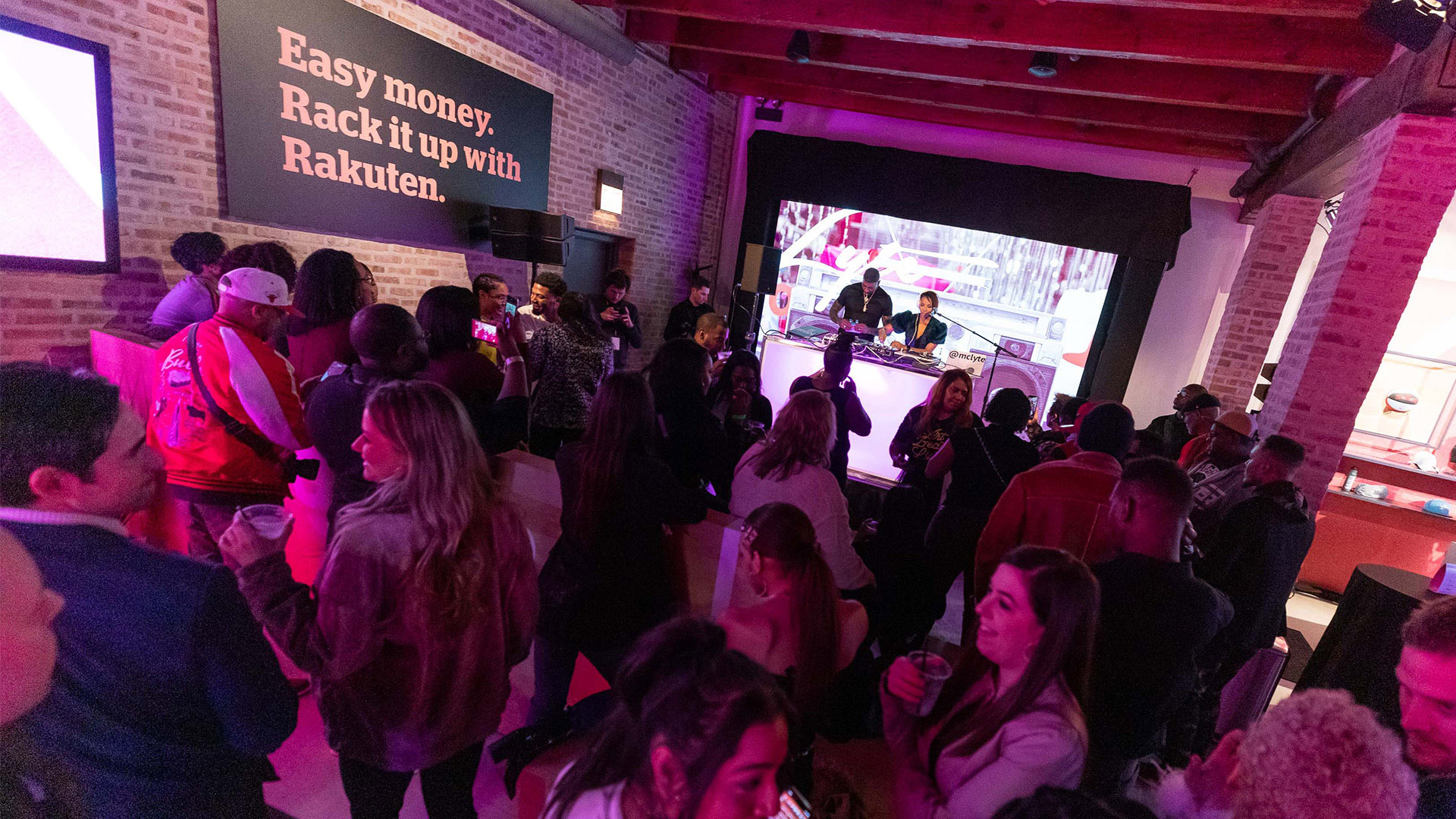 Wide view of a packed Rakuten House filled with many guests in front of the stage